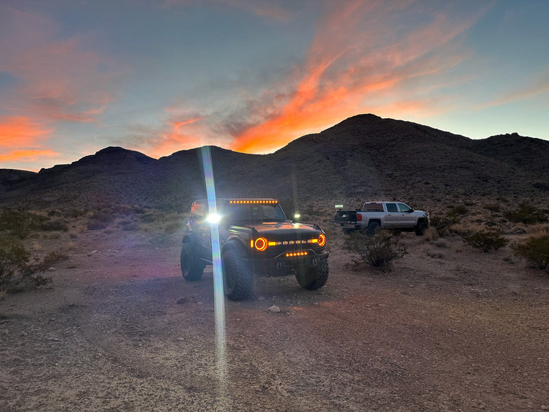 Load image into Gallery viewer, Bronco with amber LED lighting products in the desert with silver truck
