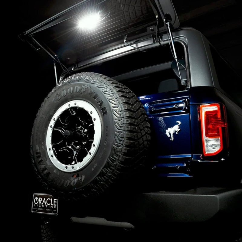Load image into Gallery viewer, Rear view of bronco with trunk open and cargo light module shining in the dark
